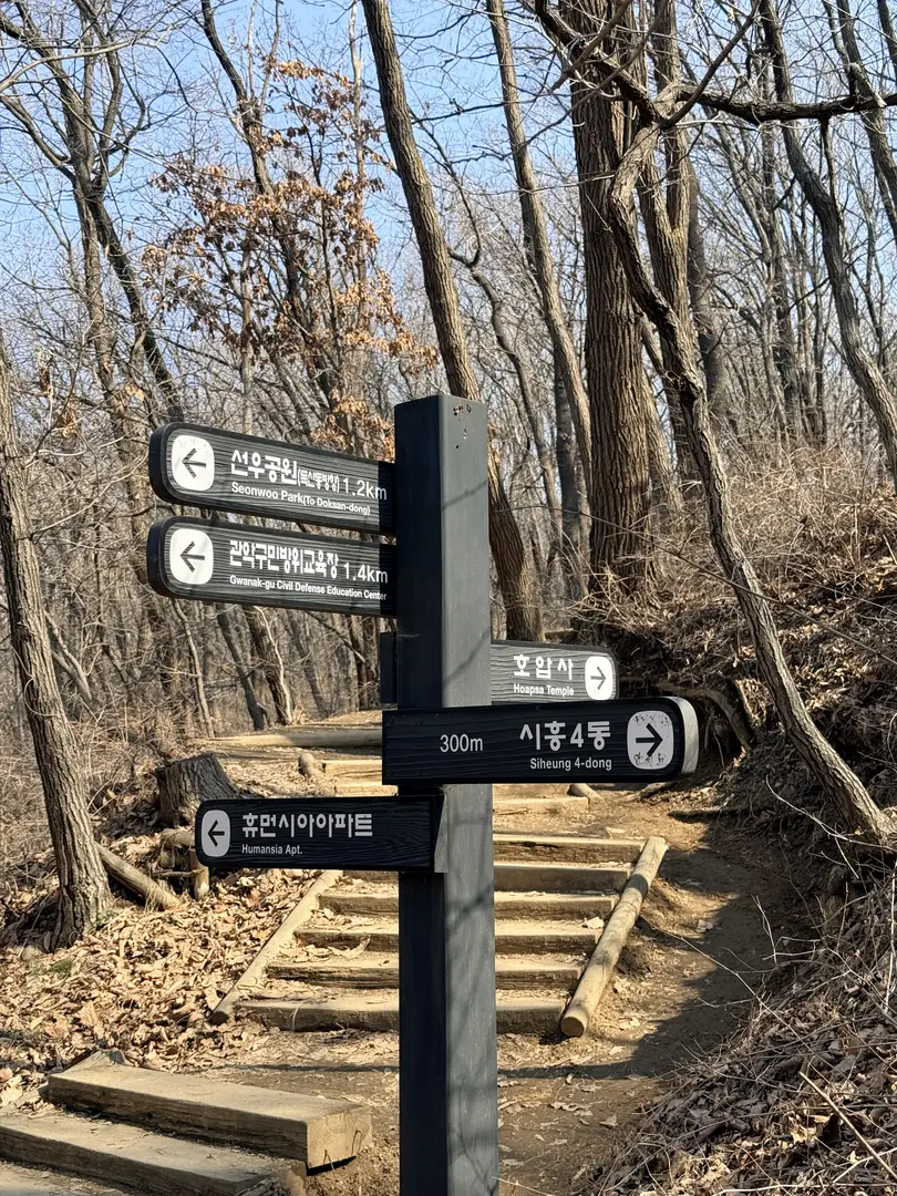 Directional hiking signs on Hoamsan Mountain trail in Seoul forest