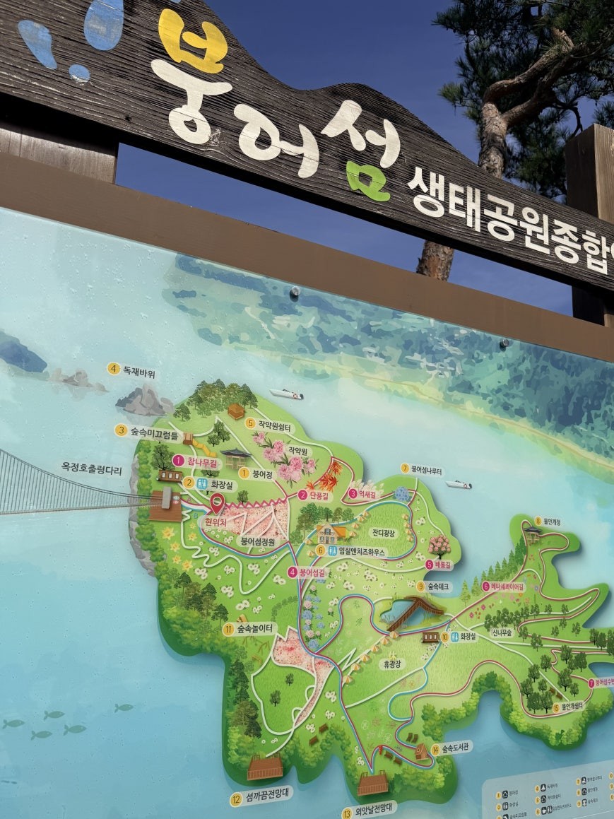 Illustrated color park map for Bungeo Island Ecological Park showing the fish-shaped island outline, numbered attractions, walking routes A and B, and the suspension bridge entry on the left